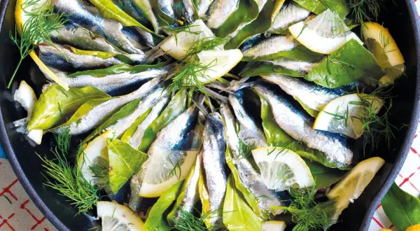Sardine in padella con limone, alloro e finocchietto fresco, pronte per essere gustate.