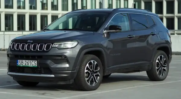 Szary Jeep Compass na parkingu. Wiele osób szuka jeep compass opinie przed zakupem.