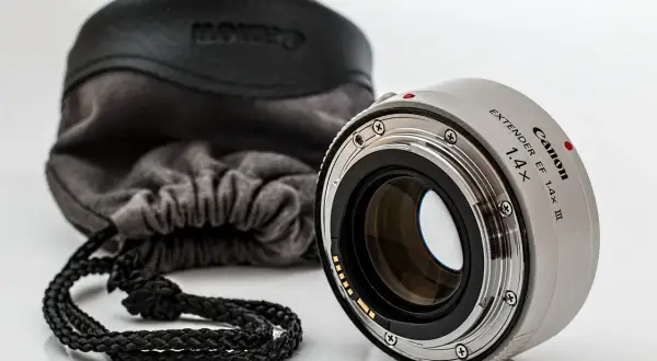 Canon Extender EF 1.4x III, czyli telekonwerter, gotowy do pracy. Obok miękki futerał z logo Canon.