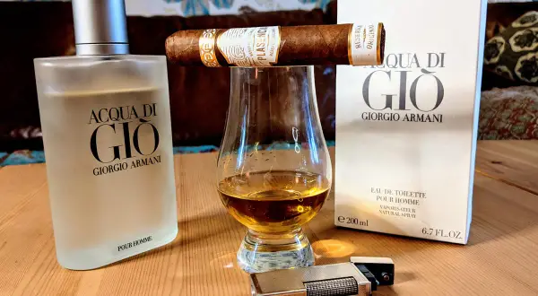 Flakon Acqua di Gio EDT, szklanka z bursztynowym płynem, cygaro i zapalniczka tworzą męski zestaw.