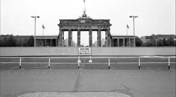 Brama Brandenburska za murem, kiedy zbudowano mur berliński. Znak ostrzega: "Uwaga, opuszczasz teraz Berlin Zachodni".