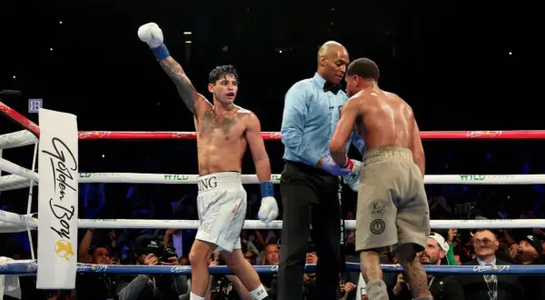 Boxer with arm raised, referee between two fighters. A majority decision in boxing means two of the three judges scored the fight for one boxer.