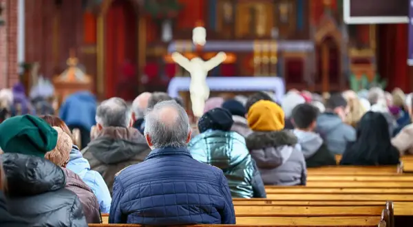 Ludzie siedzą w kościele, zastanawiając się, czy dzisiaj trzeba iść do kościoła. W tle widać ołtarz i krzyż.