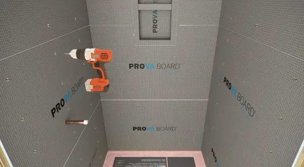 Drill in hand, ready to install concrete board for a shower. This image shows the process of how to install concrete board, with the PROVA BOARD brand visible.