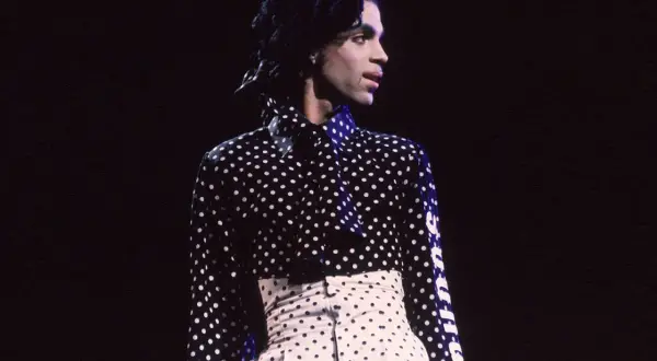 Iconico Prince con camicia a pois uomo e pantaloni a vita alta, un look audace e indimenticabile.