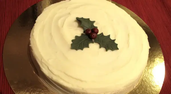 En krämig tårta med vit glasyr, dekorerad med en julstjärna av marsipan. Perfekt för julfikat!