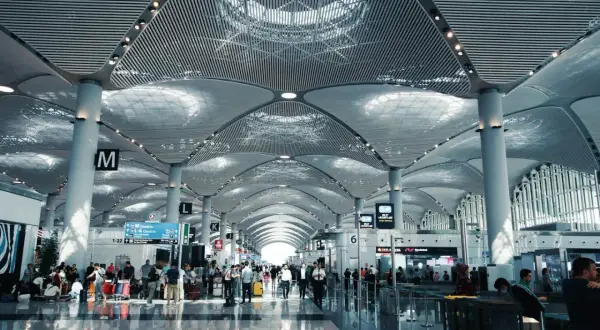 Nowoczesny terminal lotniska z ludźmi i bagażami. Zastanawiasz się, ile wcześnie być na lotnisku? Tutaj jest tłoczno.