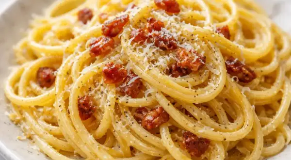 Un plat de linguine alla carbonara crémeux, garni de lardons croustillants et de parmesan râpé. Un délice italien.