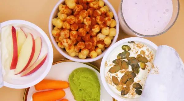 Zdrowe, niskokaloryczne przekąski: jogurt z jabłkiem, ciecierzyca z papryką, guacamole z marchewką i jogurt z pestkami dyni.