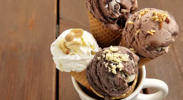Cuatro helados en conos, dos de chocolate y uno blanco con cacahuates, perfectos como helados para diabéticos tipo 2.