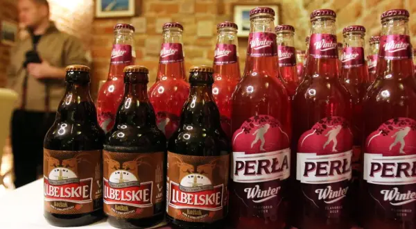 Butelki piwa Perła Winter z zimowym motywem i ciemne piwo Koźlak.