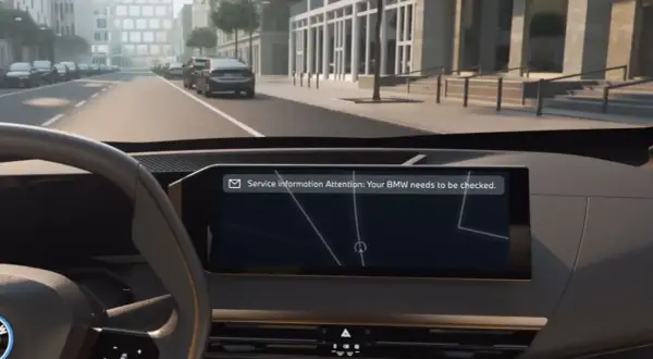 Vista interior de un BMW con mensaje de atención: "Tu BMW necesita una revisión".