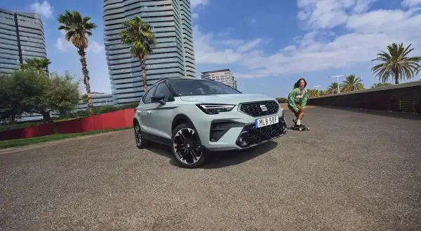 En Seat Arona står parkerad vid en strandpromenad med en person på skateboard i bakgrunden. Inga problem med denna bil.