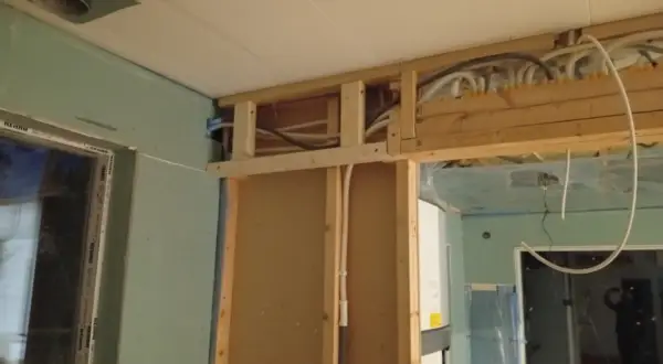 Pågående renovering av badrum med synliga rör och trästomme.