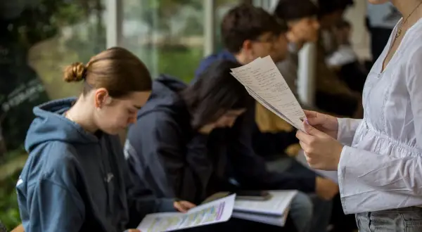Estudiantes concentrados en sus apuntes, explorando las ventajas de estudiar en el extranjero y descubriendo nuevas oportunidades.