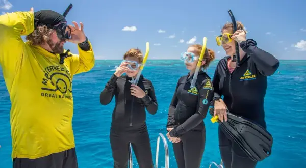 Rodzina w strojach do snorkelingu na łodzi, gotowa do zwiedzania Wielkiej Rafy Koralowej.