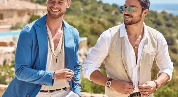 Zwei Männer in lässigen Sommer-Outfits für eine Gartenparty. Einer trägt einen blauen Blazer, der andere eine Weste.
