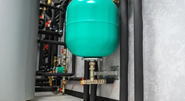 Réservoir d'expansion vert vif, partie d'un système de plomberie avec une pompe booster.