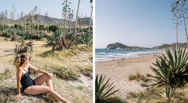 Mujer en bikini negro en la arena, rodeada de agaves. Al fondo, una playa idílica, una de las 10 mejores playas del Cabo de Gata.