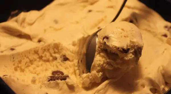 En skopa krämig vaniljglass med chokladbitar, perfekt för ett hemmagjort daimglass recept.