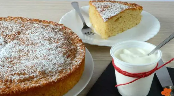 Torta yogurt vasetti soffice e profumata, spolverata di zucchero a velo, con una fetta servita accanto a una coppetta di yogurt.