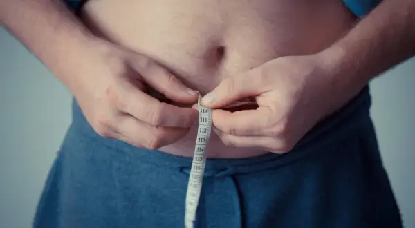 Osoba mierzy obwód talii, co może wskazywać na zaburzenia metabolizmu lipoprotein i inne lipidemie.