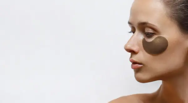 Kobieta z płatkami pod oczy. Czy retinol można stosować pod oczy? Płatki nawilżają i odżywiają delikatną skórę.