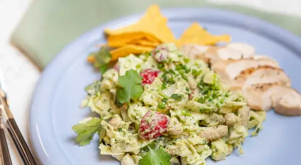 En krämig kycklingsallad med avokado och körsbärstomater, serverad med tortillachips och grillad kyckling. Ett perfekt kycklingsallad recept för en lätt lunch.