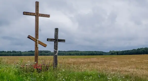 Trzy krzyże na tle pola i lasu. Jeden z nich ma napis "Spasi i Sochrani". Czy horoskopy to grzech?