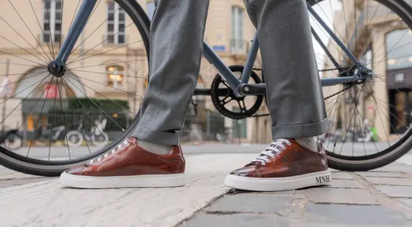 Eleganckie, brązowe sneakersy do garnituru, idealne na miejską przejażdżkę rowerem.