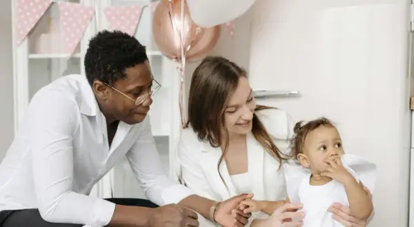 Famille célébrant la tradition du baptême. Un père, une mère et leur bébé, entourés de décorations festives.