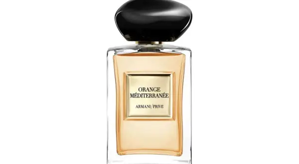 Szklana butelka z pomarańczowym płynem i czarną nakrętką. Etykieta głosi "ORANGE MÉDITERRANÉE ARMANI/PRIVE".