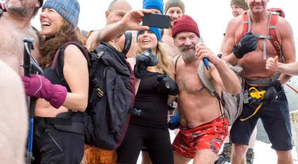 Grupa ludzi w zimnych warunkach, niektórzy bez koszulek, robi selfie. Metoda Wima Hofa niebezpieczna, ale ta grupa wydaje się cieszyć.