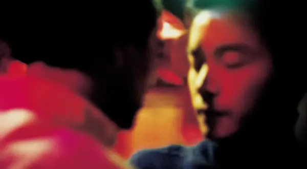 Un bacio intenso, un momento di passione tra due persone. L'atmosfera è carica di emozione, quasi come un sogno, un ricordo sfocato di Wing Shya.