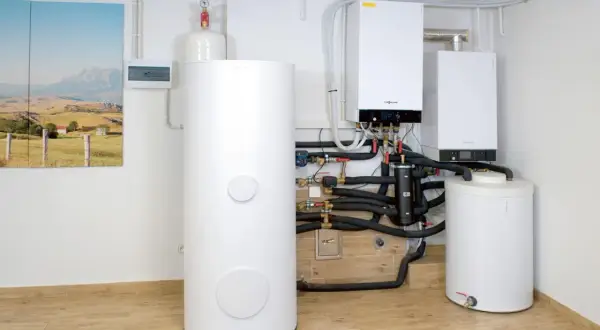 Nowoczesny kocioł gazowy z zasobnikiem i instalacją hydrauliczną w kotłowni.