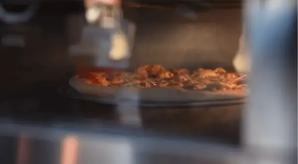 Pizza Dr. Oetker piecze się w piekarniku, parując apetycznie. Czas pieczenia zależy od modelu.