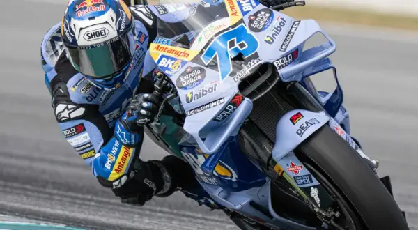 Alex Márquez inclinado en su moto azul y blanca, con el número 73 visible.