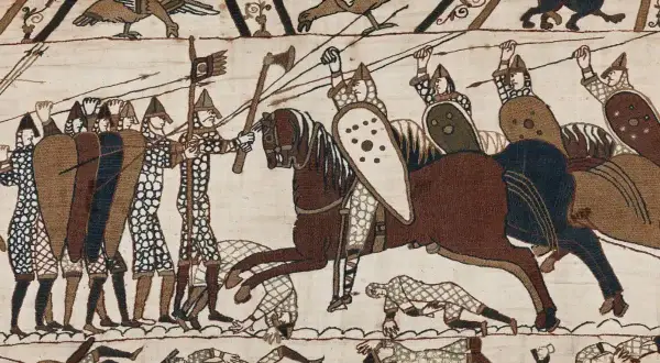 Scen från slaget vid Hastings 1066. Soldater med sköldar och spjut, en ryttare på häst. Nedanför fallna krigare.
