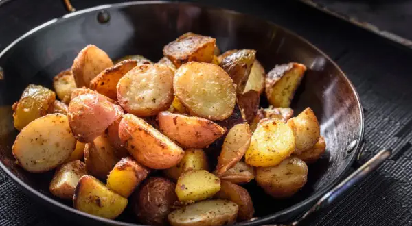 Goldbraune bratkartoffeln mit Ei, knusprig gebraten und würzig gewürzt, serviert in einer Pfanne.