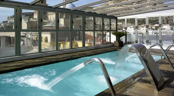 Piscina con cascadas y vistas a la ciudad, ideal para un spa bodyna Valencia.
