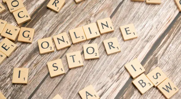 Litery na drewnianym tle układają się w słowa "ONLINE STORE". To wielka strategia dla każdego biznesu.