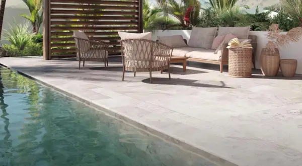 Terraza junto a piscina con mobiliario de exterior. El suelo antideslizante es el mejor suelo para exterior, seguro y elegante.
