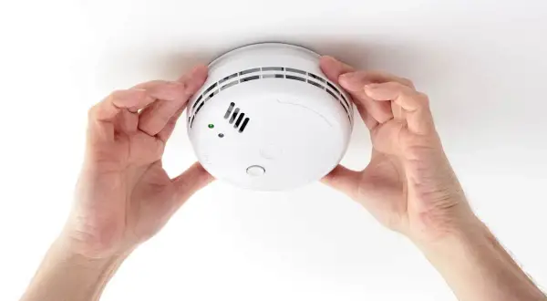 Installation d'un détecteur de fumée. Ce geste garantit votre sécurité et constitue une attestation de détecteur de fumée valide.