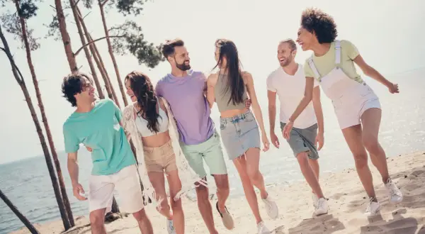 Glatt gäng på stranden, redo för en tipspromenad med frågor för en 30-årsfest. Sol, sand och skratt!