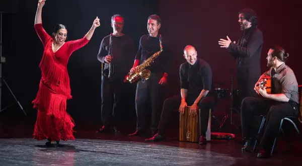 Fuensanta la Moneta, bailaora flamenca, levanta los brazos con pasión. La acompaña un grupo de músicos con saxofón, clarinete, cajón y guitarra.
