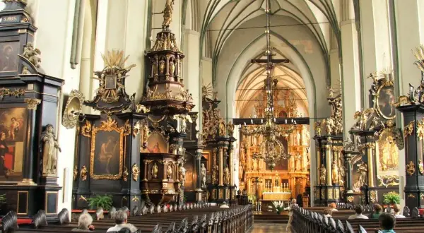 Wnętrze kościoła św. Mikołaja w Gdańsku, pełne bogatych zdobień i ołtarzy.