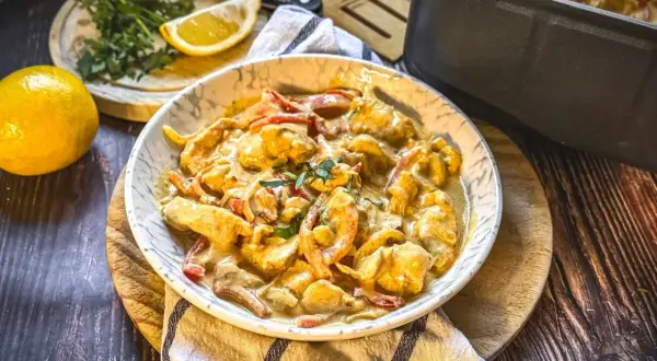Cremiges Hähnchengeschnetzeltes mit Paprika in einer Schüssel, garniert mit Kräutern. Ein leckeres geschnetzeltes Rezept für jeden Tag.