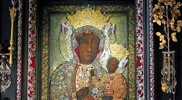 Obraz Matki Boskiej Częstochowskiej w bogatych szatach, z Dzieciątkiem Jezus. Wizerunek ten, znany z Jasnej Góry, można podziwiać w określone godziny odsłonięcia.