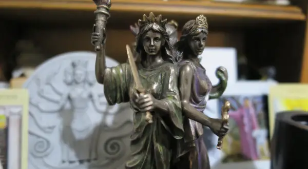 Figurka Hekate z pochodnią i mieczem, symbolizująca jej moc nad magią i przejściami.