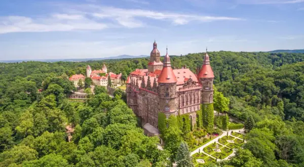 Majestätisches Schloss Kynast, eingebettet in grüne Wälder in Niederschlesien, mit roten Dächern und gepflegten Gärten.
